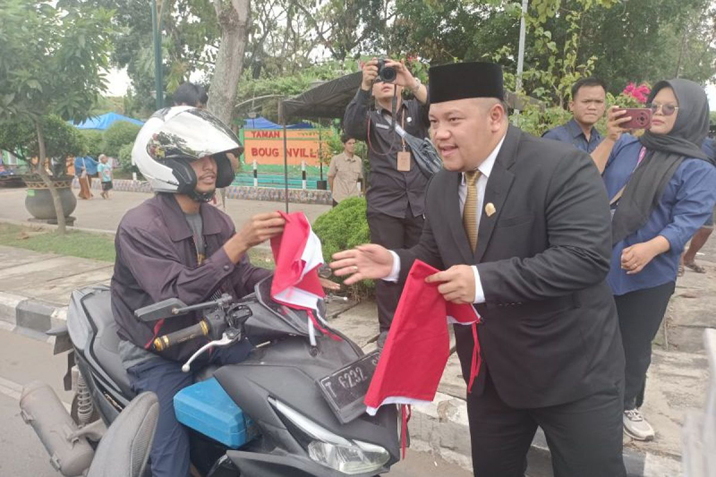 D:\2025\Agustus 2025\19 Agustus 2025\5\hal 5\Ketua DPRD Kota Banjarbaru Gusti Rizky Sukma Iskandar Putera saat membagikan bendera.jpg