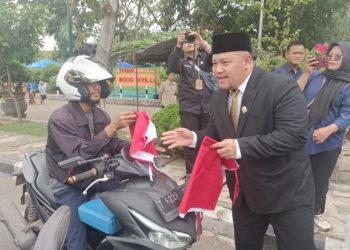 D:\2025\Agustus 2025\19 Agustus 2025\5\hal 5\Ketua DPRD Kota Banjarbaru Gusti Rizky Sukma Iskandar Putera saat membagikan bendera.jpg