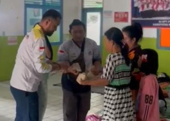 G:\2025\2026\Januari\6 Januari 2026\5\hal 5\Petugas dari posko dapur umum membagikan makana.jpg