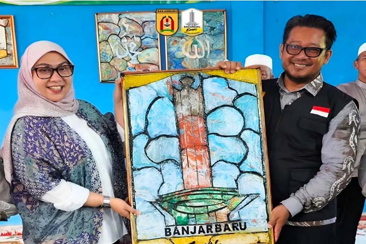 Walikota Lisa Ajak Warga Ubah Sampah Jadi Berkah WALIKOTA Banjarbaru Erna Lisa Halaby menerima cenderamata berupa lukisan logo Banjarbaru EMAS hasil pemanfaatan tutup botol air mineral di sela peringatan satu tahun Program Markissa di Kelurahan Syamsudin Noor, Selasa (16/6). (Foto:mb/ant/mc kominfo bjb)