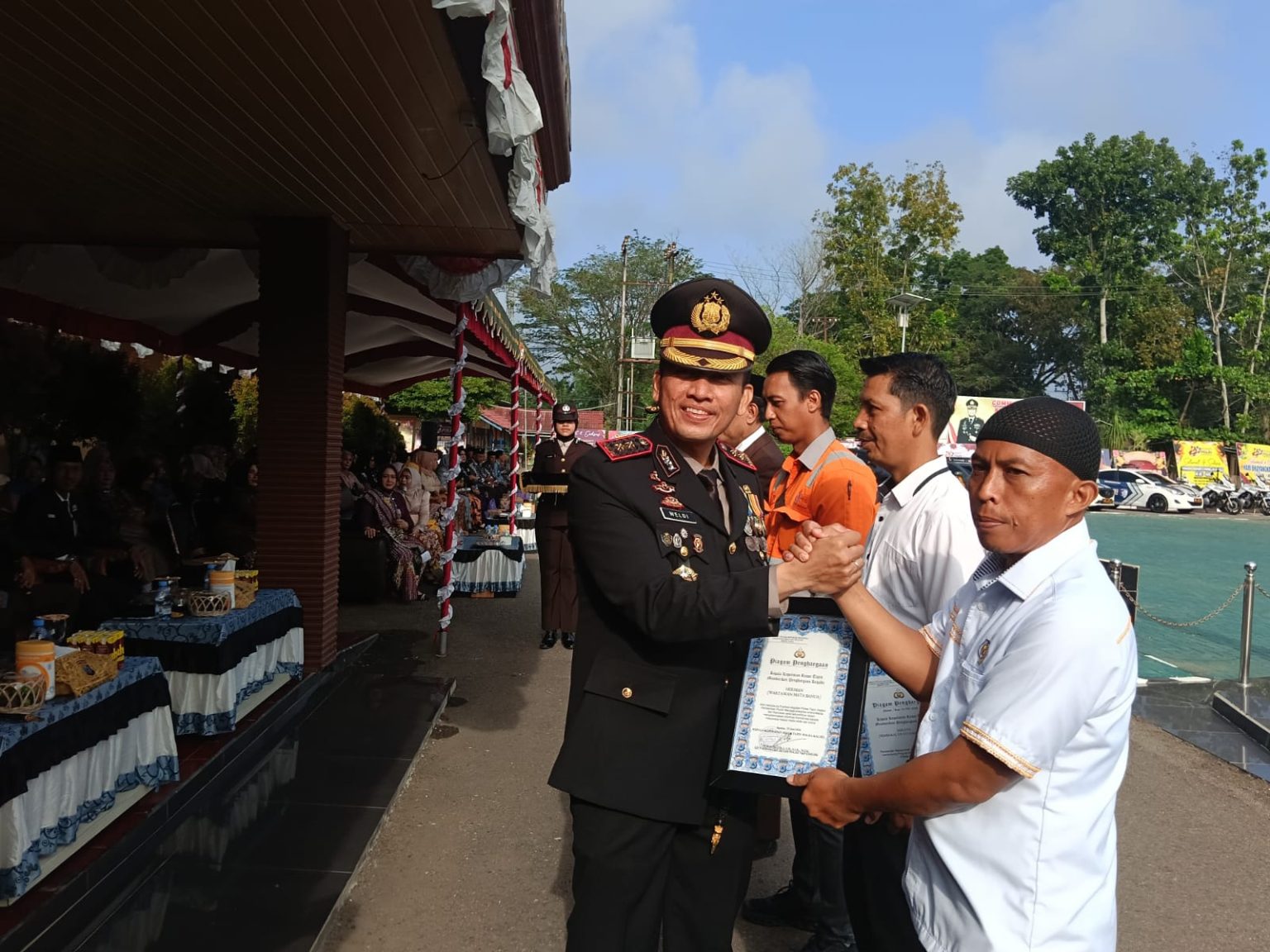 Polres Tapin Gelar Upacara HUT Bhayangkara TERIMA PENGHARGAAN - Kapolres Tapin AKBP Weldi Rozika SH SIK MIK saat memberikan penghargaan kepada wartawan Harian Pagi Mata Banua Herman Hidayat pada puncak HUT ke-80 Bhayangkara, Rabu (1/7). (Foto: mb/her)