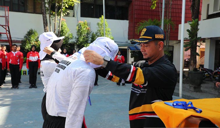 Banjarmasin Pilih 34 Calon Paskibra HUT ke-81 RI SEKDAKOTA Banjarmasin Ichrom Muftezar mengalungkan tanda peserta menandai pembukaan secara resmi pemusatan pendidikan dan pelatihan Calon Paskibra 2026 di halaman belakang Balaikota, Minggu (19/7). (Foto:mb/ant/pemko bjm)