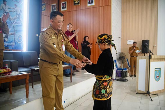 Disbudporapar Banjar Gelar Kejurda SEKDA Kabupaten Banjar H Yudi Andrea menyerahkan sebilah golok kepada salah satu pesilat yang akan menampilkan atraksi di pembukaan Kejurda Tingkat Pelajar Tahun 2026.(foto:mb/ist)