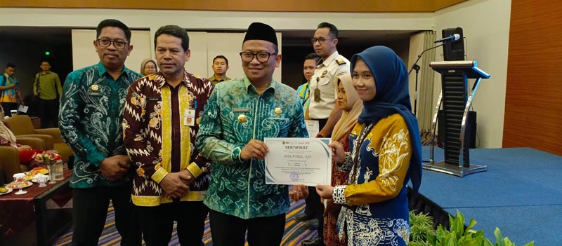 Bupati Tutup Bimtek Pengarusutamaan Gender Bupati Tabalong, H Muhammad Noor Rifani Saat Menyerahkan Sertifikat Pelatihan Kepada Salah Satu Peserta. (foto:mb/yan)