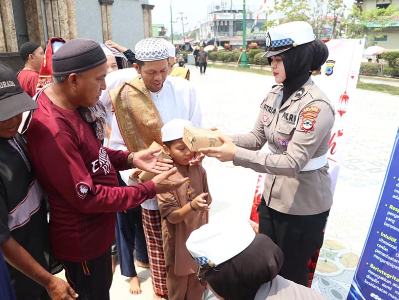 Polres Tabalong Berbagi di Jumat Berkah SALAH satu polwan saat membagikan makanan pada kegiatan Jumat Berkah.(foto:mb/ist)