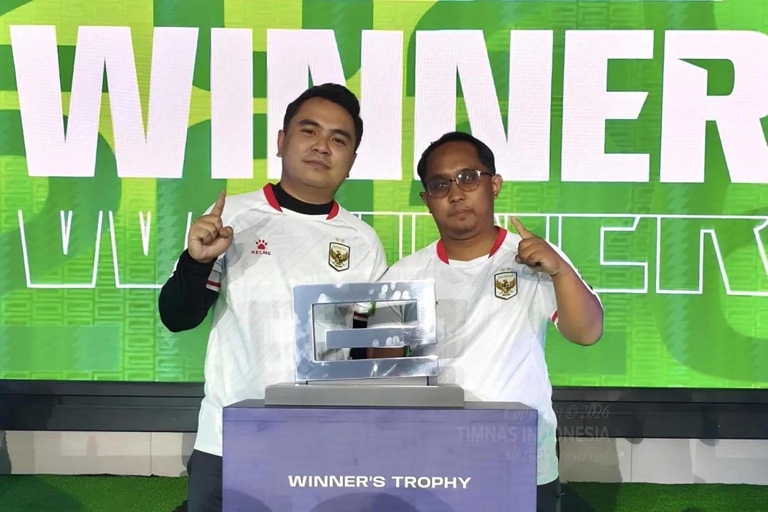 Indonesia Juara FIFAe Continental Championship 2026 Asia Berfoto Bersama - Tim eFootball konsol Indonesia, Mohammad Akbar Paudie (kiri) bersama Elga Cahya Putra (kanan), berfoto bersama dengan trofi usai menjuarai FIFAe Continental Championship 2026 Asia Football Console, Sabtu (22/8).(foto;mb/ Instagram.com/timnasindonesiaTangkap layar)