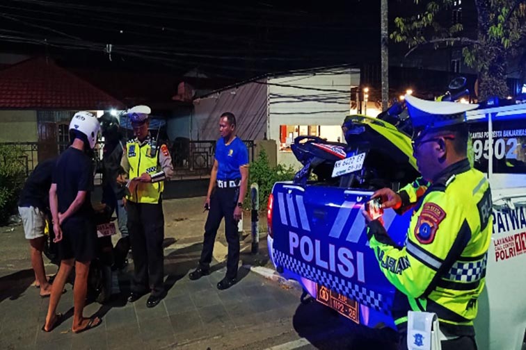 Satlantas Tindak 20 Pelanggar Aksi Balap Liar PERSONEL Satlantas Polresta Banjarmasin sedang melakukan penindakan terhadap pengendara sepeda motor karena melakukan pelanggaran yang berpotensi balap liar, Banjarmasin, Sabtu (1/8) dini hari.(foto:mb/ant)