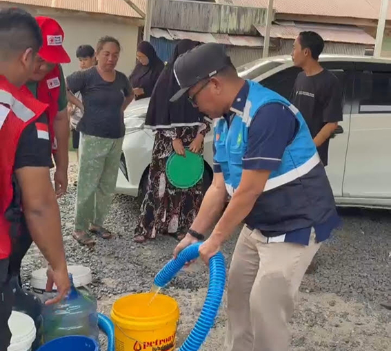 Krisis Air, PAM Bandarmasih Siapkan Rencana Bangun Infrastruktur Ketahanan Air Baku DIRUT PAM Bandarmasih membantu penyaluran air tangki ke penampungan milik warga.(foto:mb/ist)