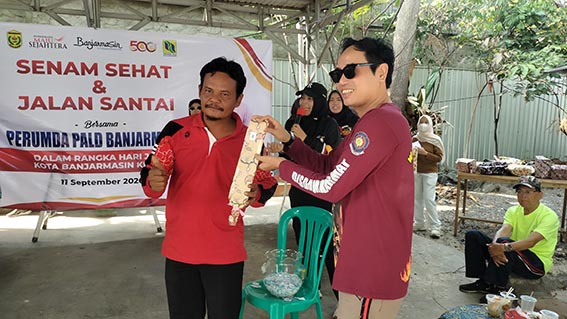Perumda PALD Ajak Masyarakat Hidup Sehat DIRUT Perumda PALD Endani Kastien memberikan hadiah doorprice kepada warga.(foto:mb/ist)