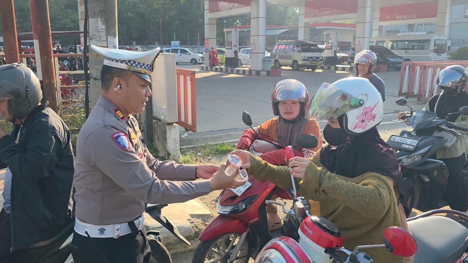 KASAT Lantas AKP Oki Hermawan saat membagikan air mineral kepada masyarakat di SPBU Mabuun, Kecamatan Murung Pudak, Senin (14/9).(foto;mb/ist)
