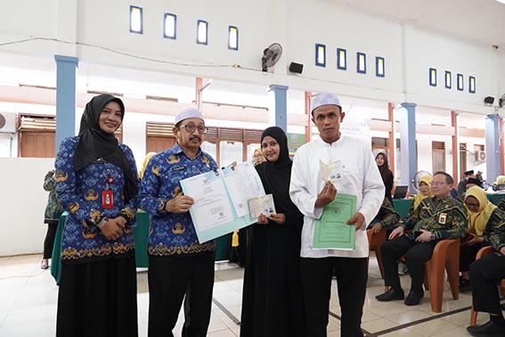 Puluhan Pasangan dapat Layanan Nikah Gratis WABUP Banjar Habib Idrus Al Habsyi secara simbolis menyerahkan buku nikah dari KUA dan dokumen kependudukan dari Disdukcapil Kabupaten Banjar kepada satu pasangan suami isteri.(foto:mb/ist)