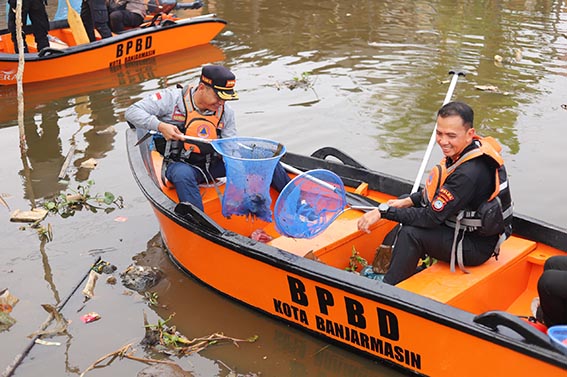 Polresta dan Pemko Banjarmasin Sinergi Bersihkan Sungai Pemurus Walikota Banjarmasin, HM Yamin bersama Kapolresta Banjarmasin, Kombes Pol Riza Muttaqin, satu perahu BPBD ketika membersihkan sampah di Sungai Pemurus. (foto:mb/ist)