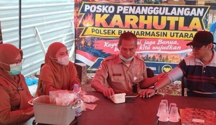 Tim Kesehatan Banjarmasin Layani Petugas dan Relawan Karhutla PETUGAS Dinkes Banjarmasin saat memeriksa kesehatan petugas di Posko Siaga Karhutla di Banjarmasin Utara, Rabu (7/10). (Foto:mb/ant/dinkes bjm)
