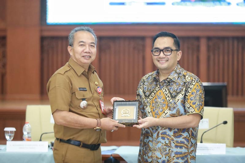 Gubernur Muhidin Dorong Penyusunan RUU Secara Komprehensif SEKDAPROV Kalimantan Selatan dan Ketua Komisi II DPR RI, Muhammad Rifqinizamy Karsayuda saling tukar cinderamata di sela rapat konsultasi publik penyusunan empat naskah akademik dan draf RUU kabupaten/kota di Kalsel.